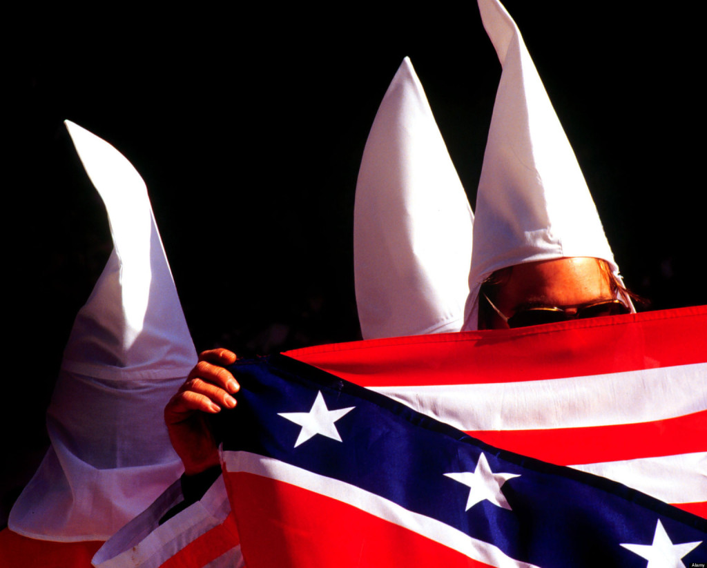 Members of the Ku Klux Klan turn their backs to the cameras or hide their faces during a rally held in New York City