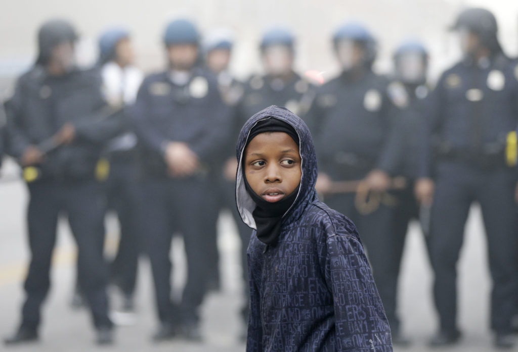 Police move a protester back, Monday, April 27, 2015, following the funeral of Freddie Gray in Baltimore. (AP Photo/Matt Rourke)